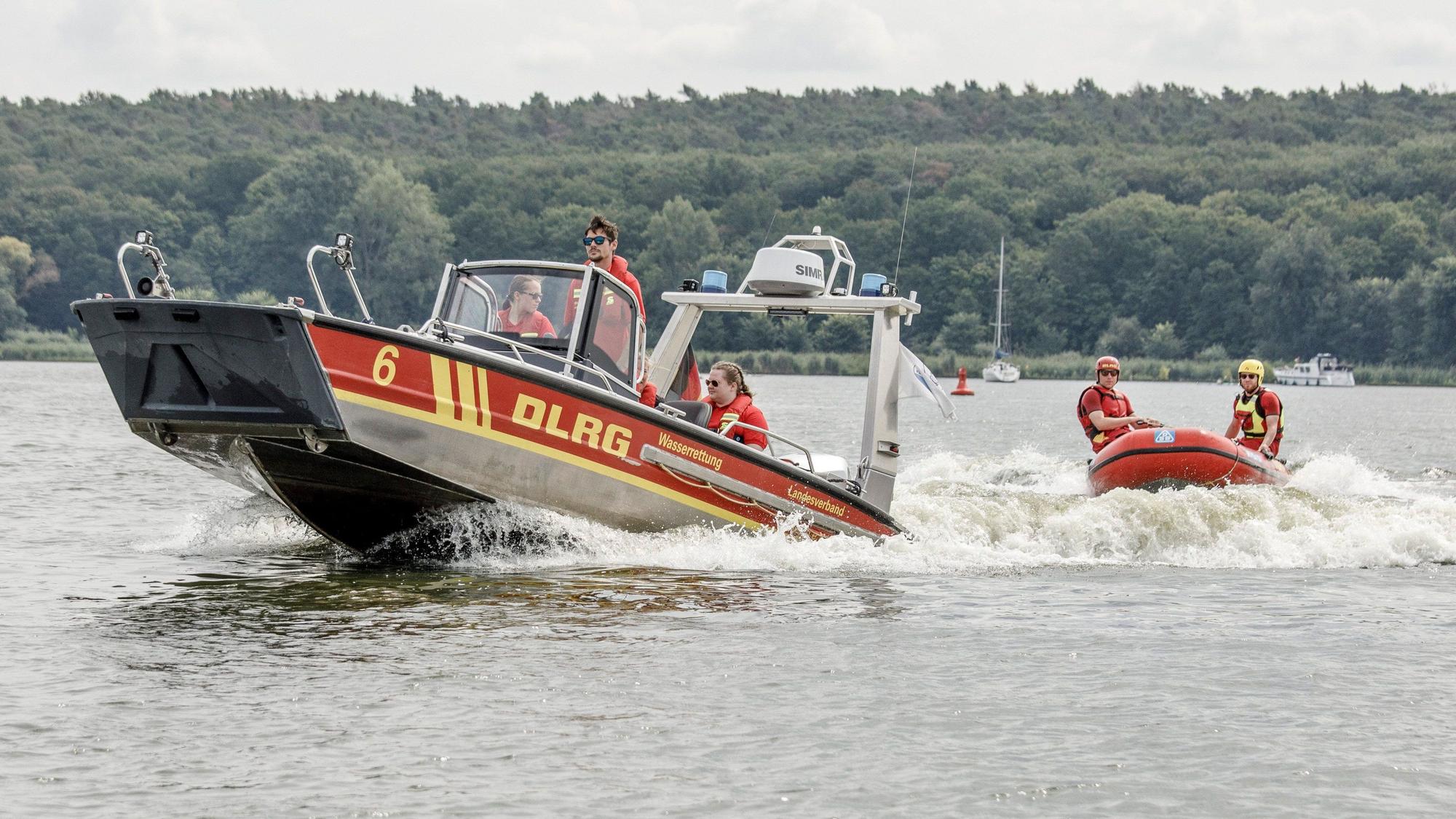 Mitglieder der Deutschen Lebens-Rettungs-Gesellschaft fahren über einen Fluss.
