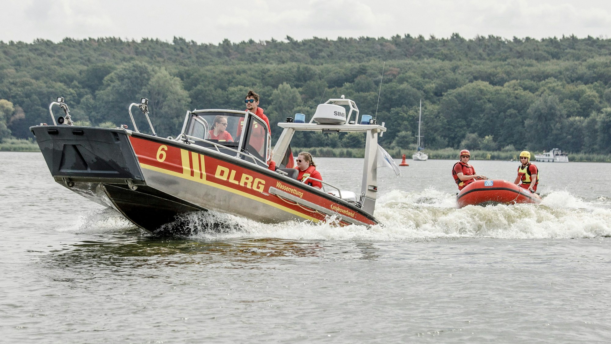 Mitglieder der Deutschen Lebens-Rettungs-Gesellschaft fahren über einen Fluss.