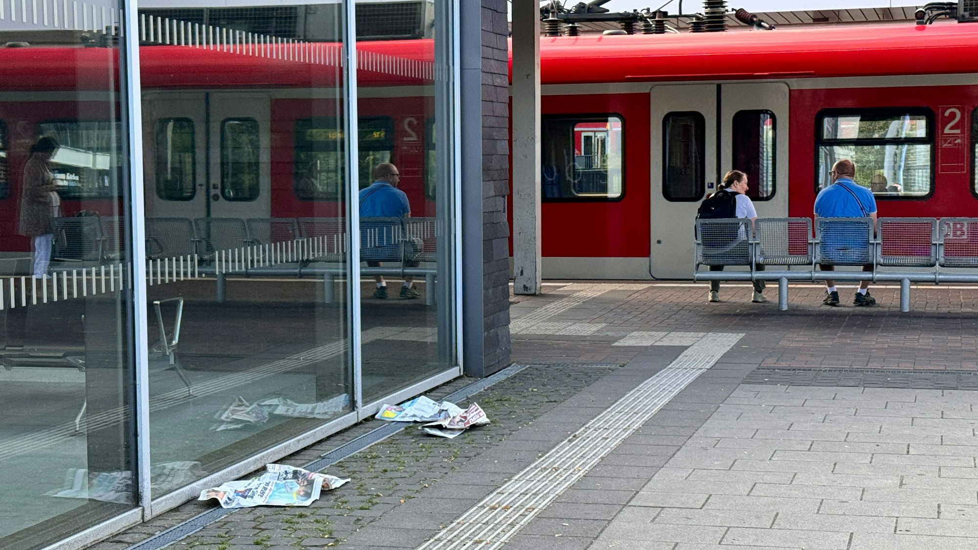 Zeitungen liegen am Bahnhof Horrem auf dem Boden.