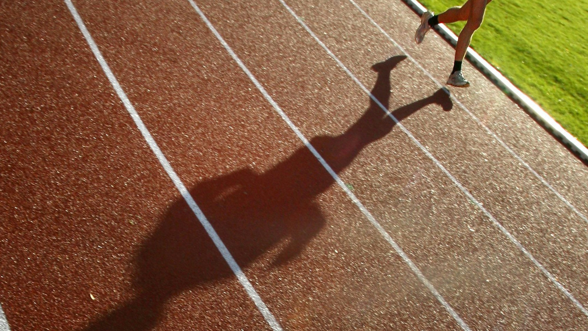 Ein Läufer läuft auf einer Tartanbahn