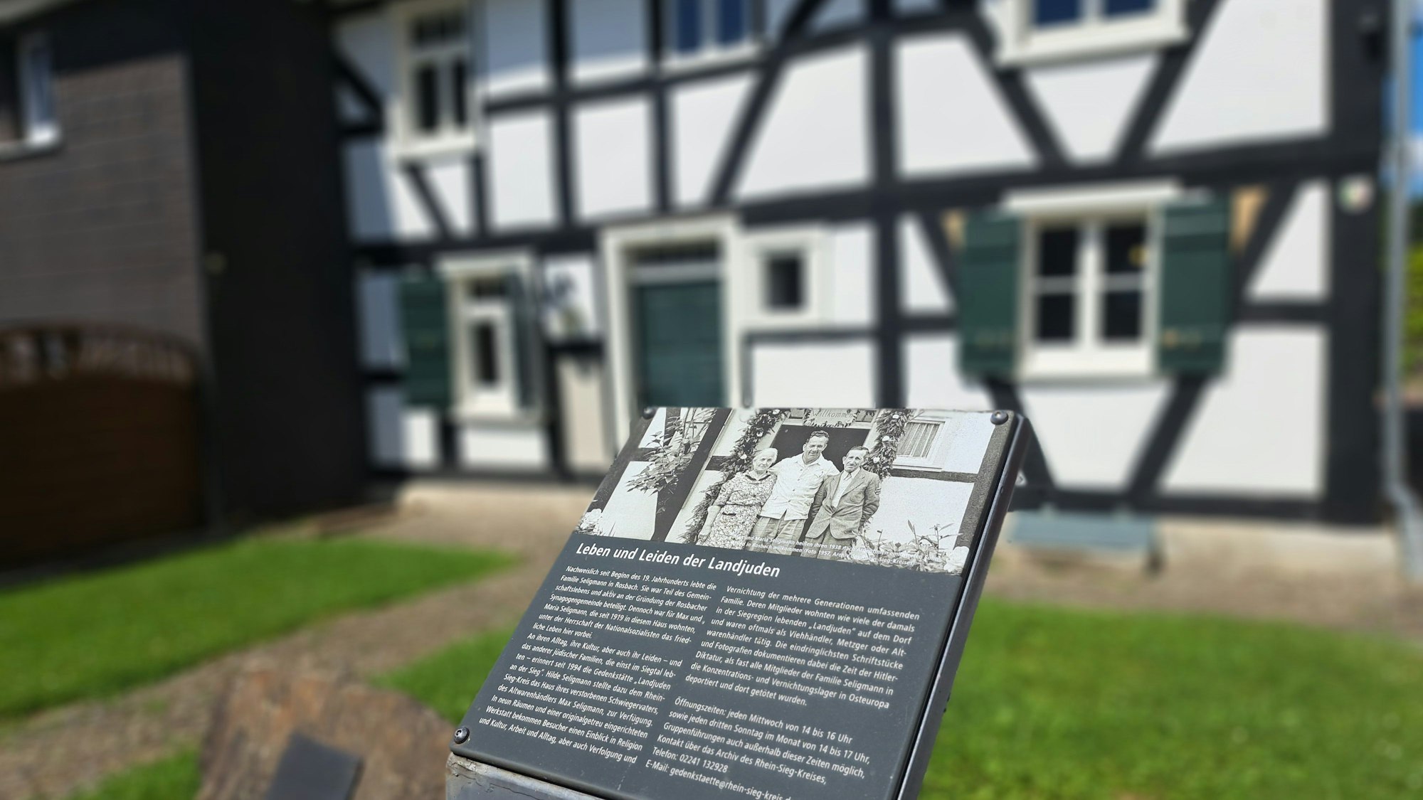 Vor dem Fachwerkhaus der Gedenkstätte "Landjuden an der Sieg" erinnert eine Infotafel an die von den Nationalsozialisten verfolgte jüdische Familie Seligmann.