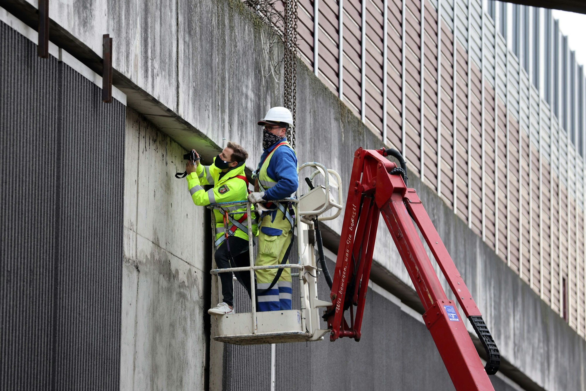Kriminalbeamte und Mitarbeiter von Straßen NRW untersuchen die Betonplatten an der Lärmschutzwand der A3.