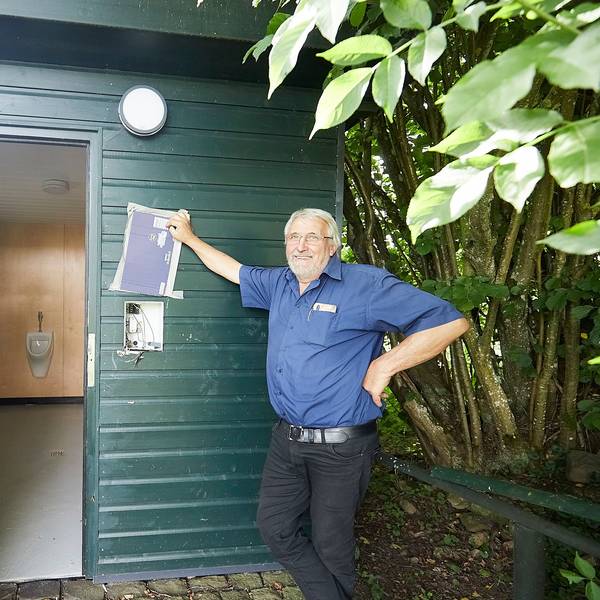 Heinz Schmitz und Gerhard Mayer stehen am Eingang des Toilettenhäuschens. Dort ist der Münzautomat aus der Wand gerissen.