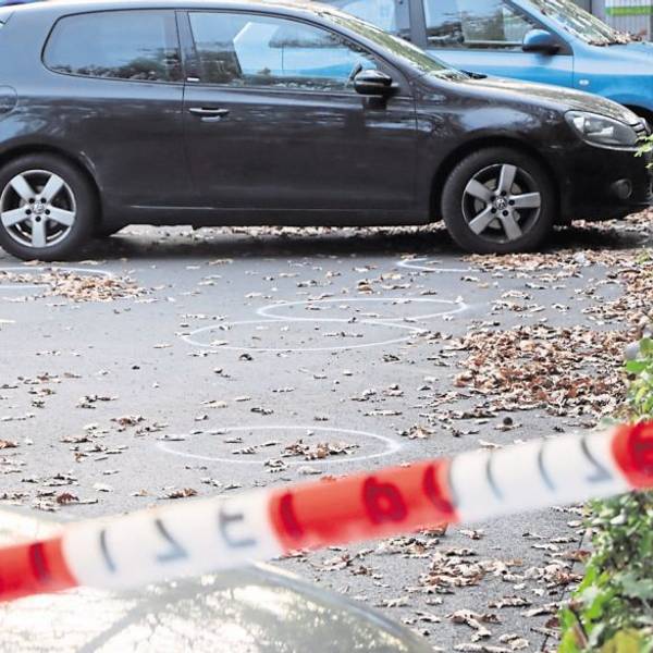 Auf dem Bild ist der Parkplatz zu sehen, auf dem ein Mann in Hürth eine Frau mit Schüssen verletzte. Auf dem Boden sind mit Kreise kreise eingezeichnet. Es parken Autos dort, der Platz ist abgesperrt.