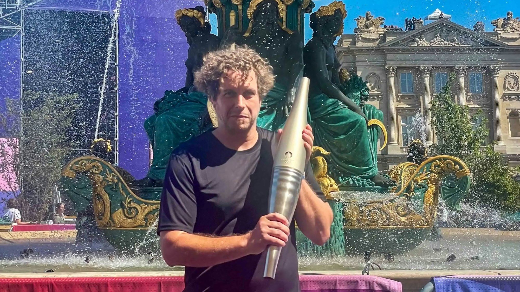 Redakteur Tom Steinicke hält die Olympische Fackel, allerdings brennt diese nicht.