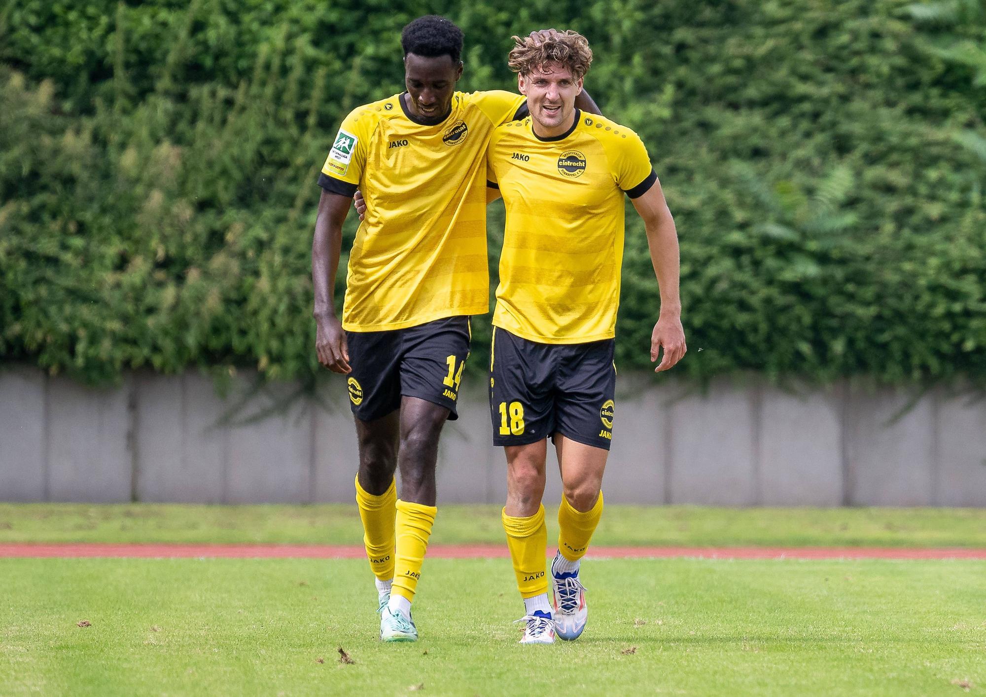 Mit den Armen über den Schultern gehen die Hohkeppeler Fußballer Mike Owuso und Enzo Wirtz über den Platz.