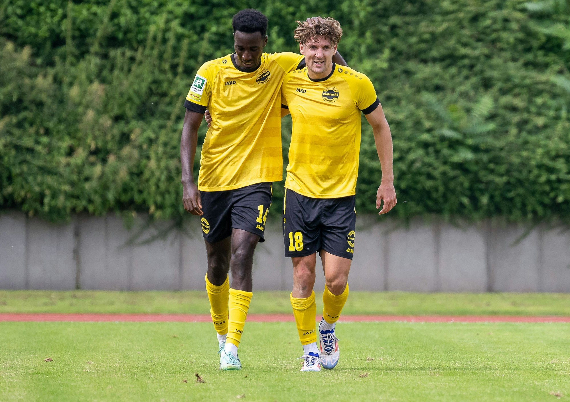 Mit den Armen über den Schultern gehen die Hohkeppeler Fußballer Mike Owuso und Enzo Wirtz über den Platz.