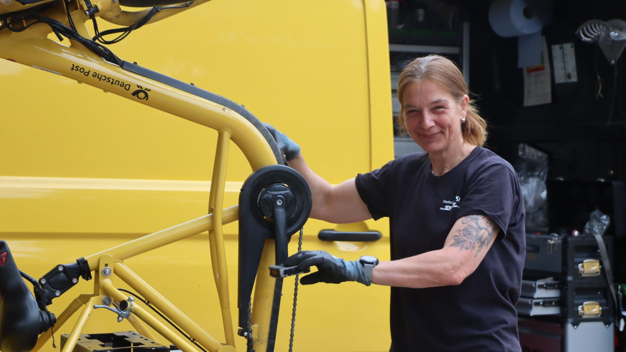 Das Bild zeigt Claudia Spohr mit ihrem Werkzeug-Wagen an einem Fahrrad.