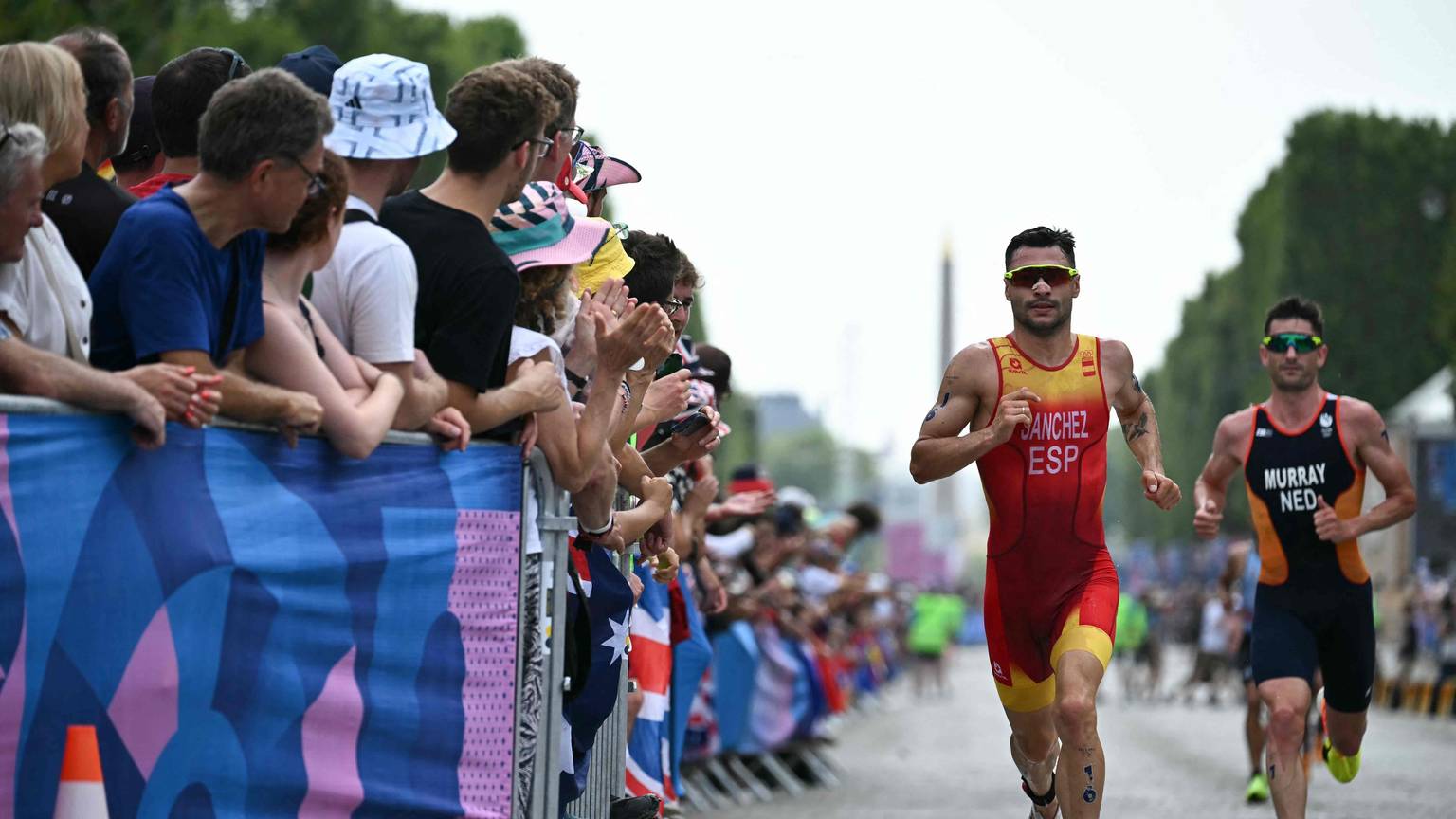 Spain's Roberto Sanchez Mantecon and Netherlands' Richard Murray compete in the running stage during the men's individual triathlon at the Paris 2024 Olympic Games in central Paris on July 31, 2024. (Photo by Ben STANSALL / AFP)