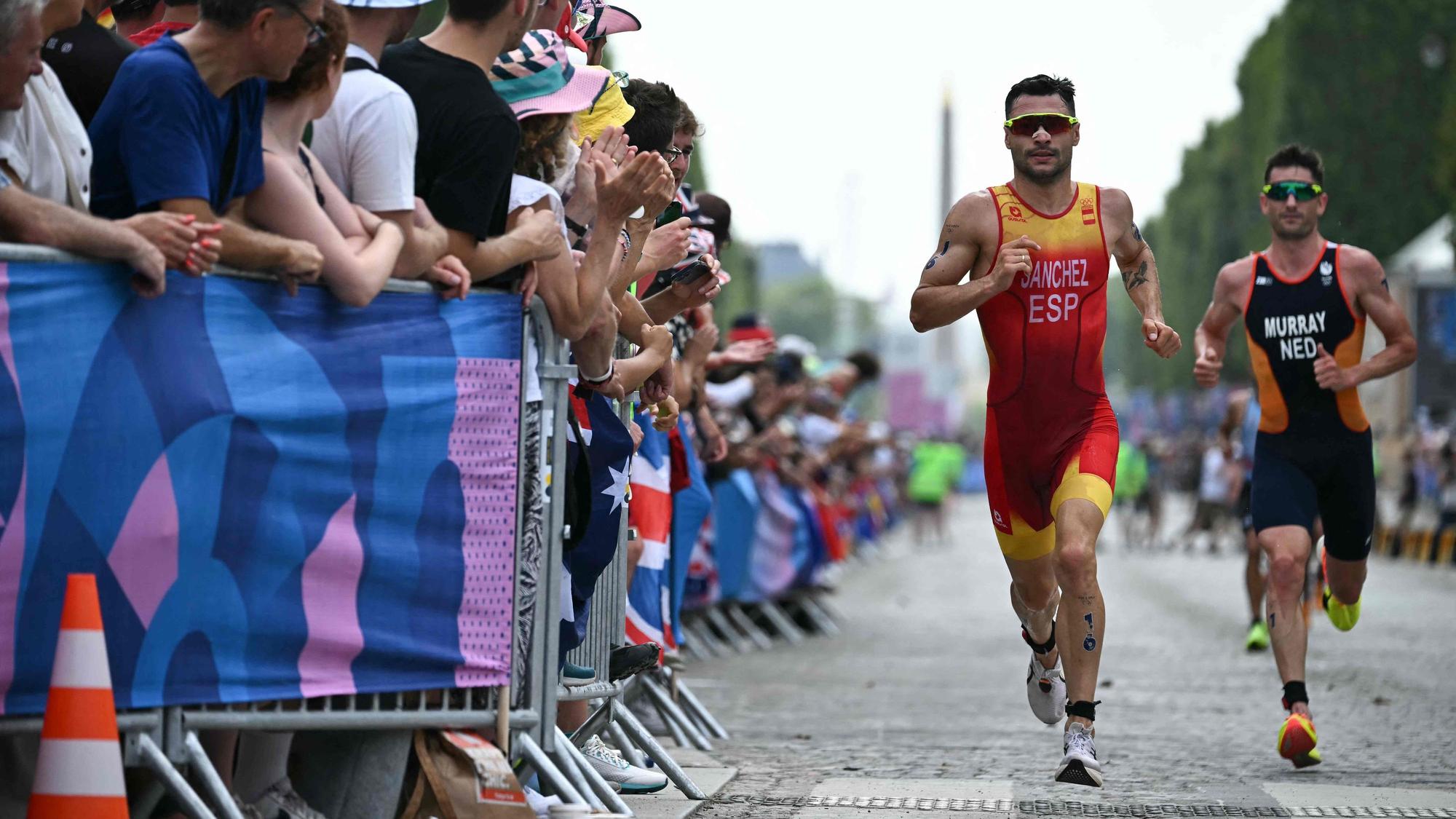 Spain's Roberto Sanchez Mantecon and Netherlands' Richard Murray compete in the running stage during the men's individual triathlon at the Paris 2024 Olympic Games in central Paris on July 31, 2024. (Photo by Ben STANSALL / AFP)