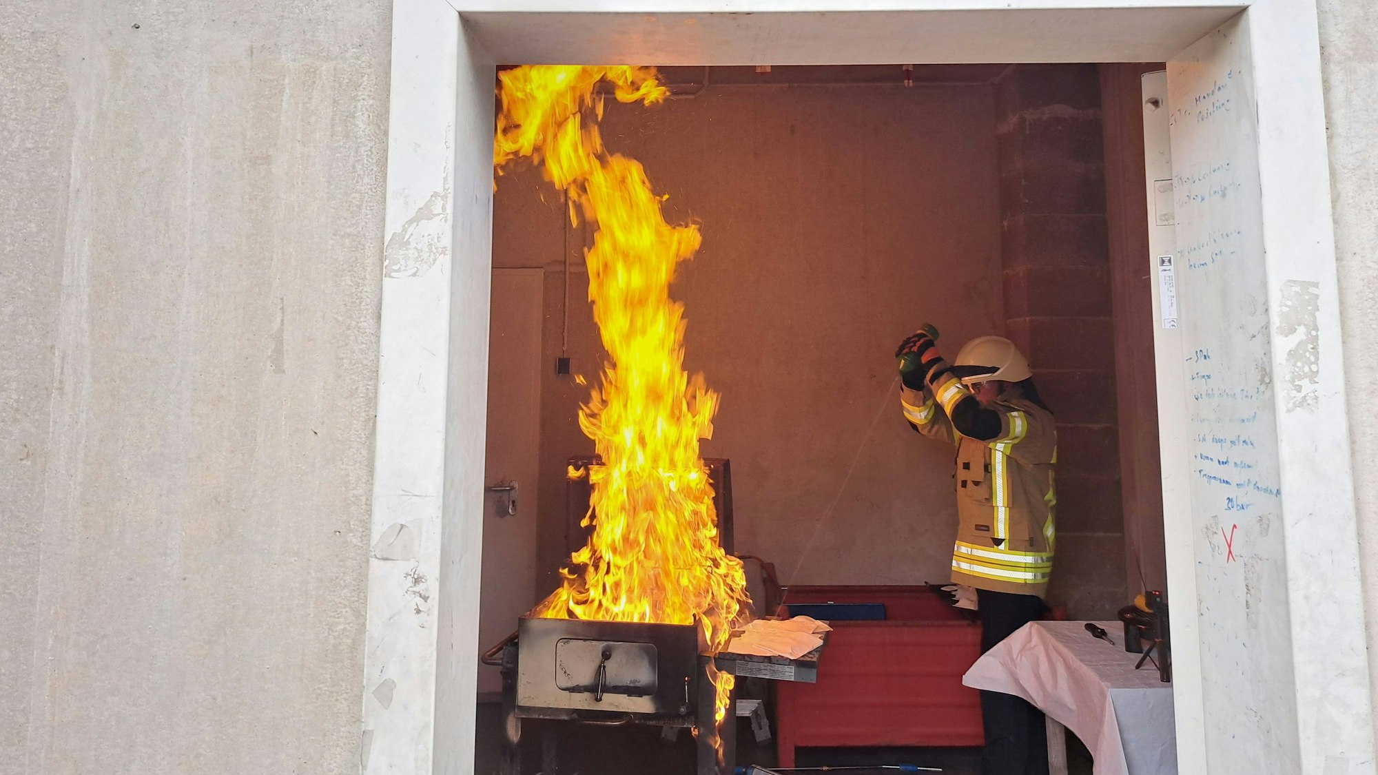 Ein Feuerwehrmann demonstriert am Kohlegrill den Einsatz von Spiritus.