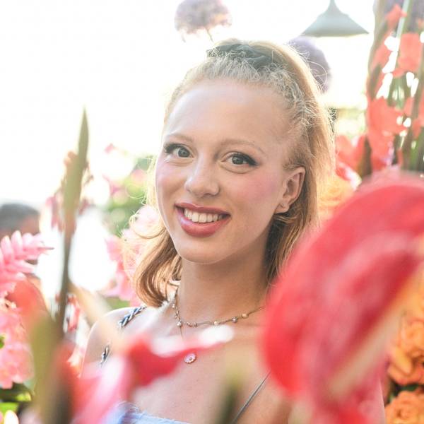 Anna Ermakova steht lachend in einem Blumenmeer.