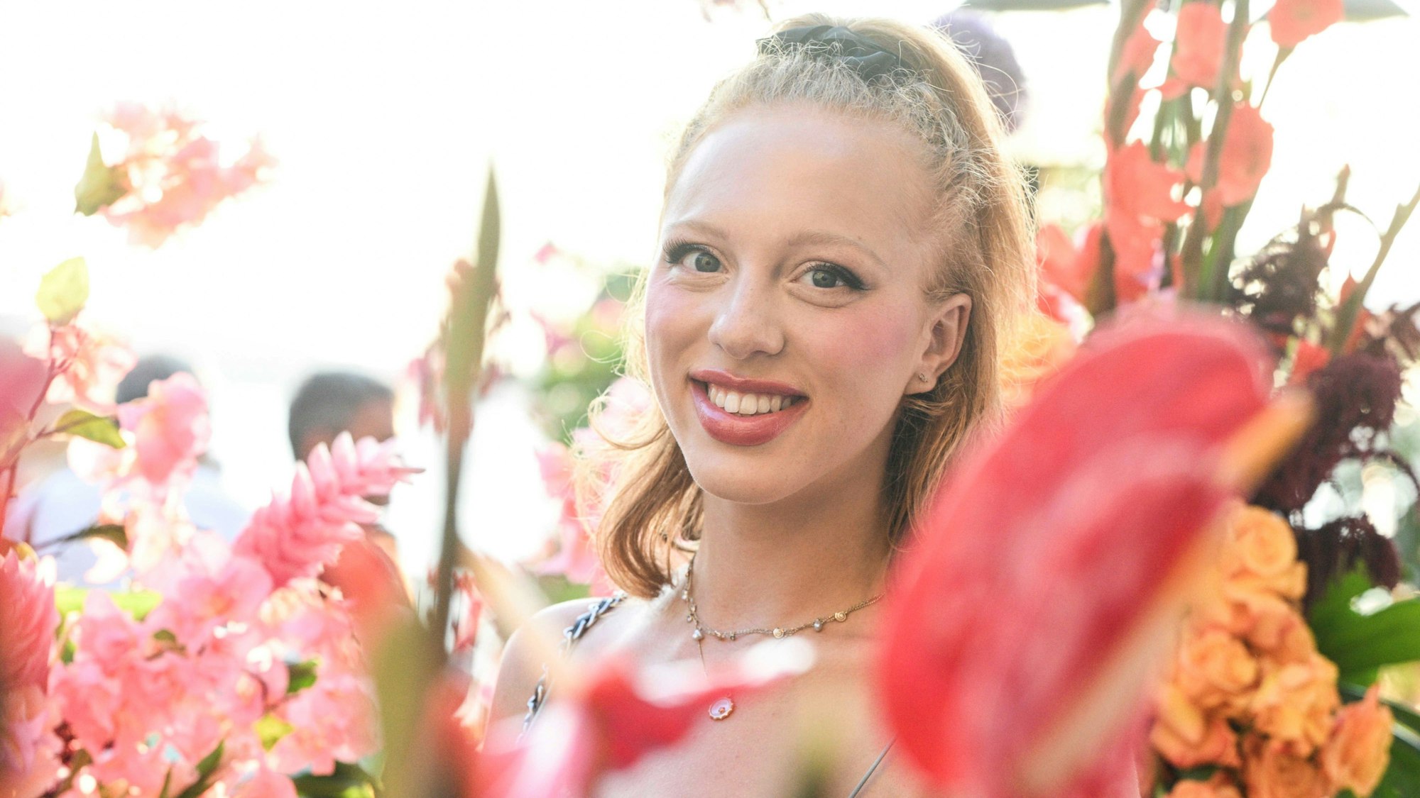 Anna Ermakova steht lachend in einem Blumenmeer.