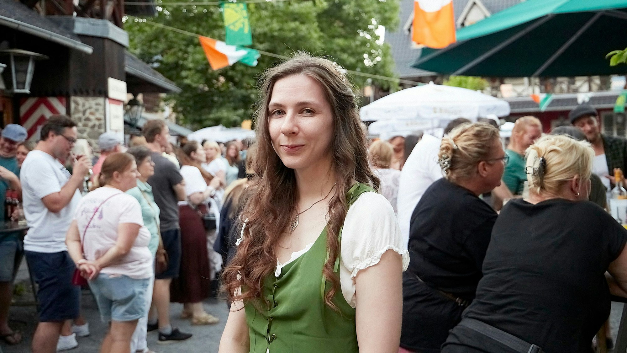 Rebecca Reichwald steht mit Haarkranz vor Besuchern.