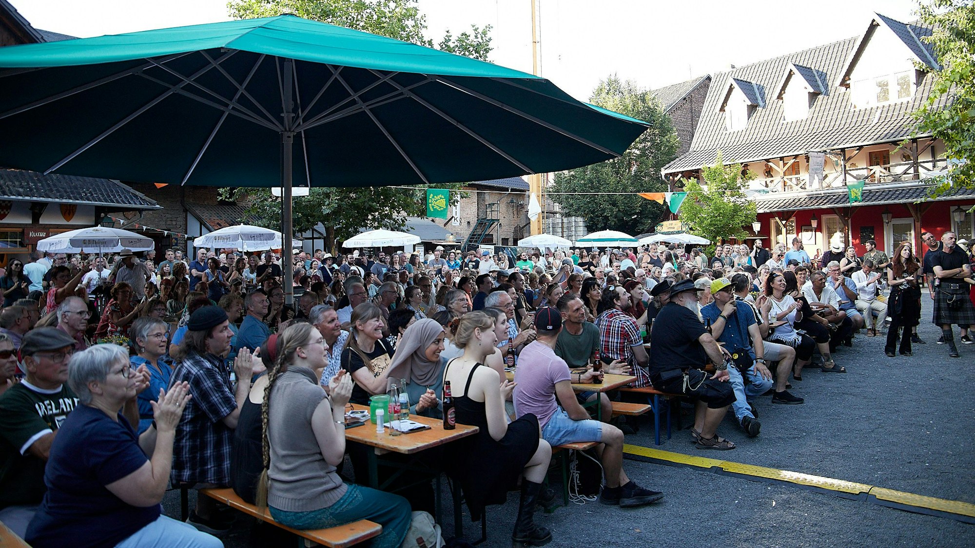 Blick auf die zahlreichen Besucher auf Bänken, die zur Irischen Nacht auf der Burg Satzvey gekommen waren.