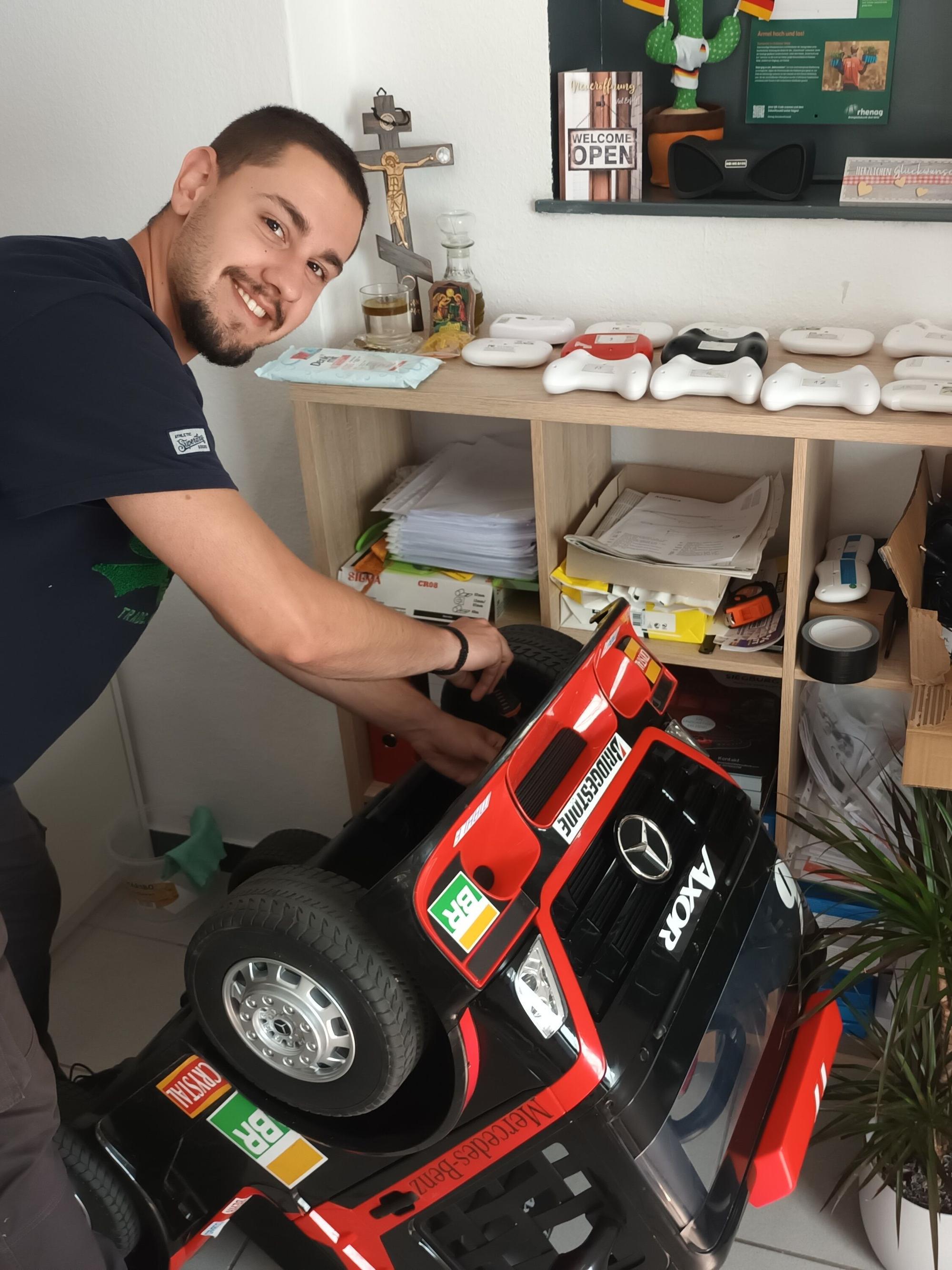Ein Mann wechselt an einem Mini-Lkw die Reifen