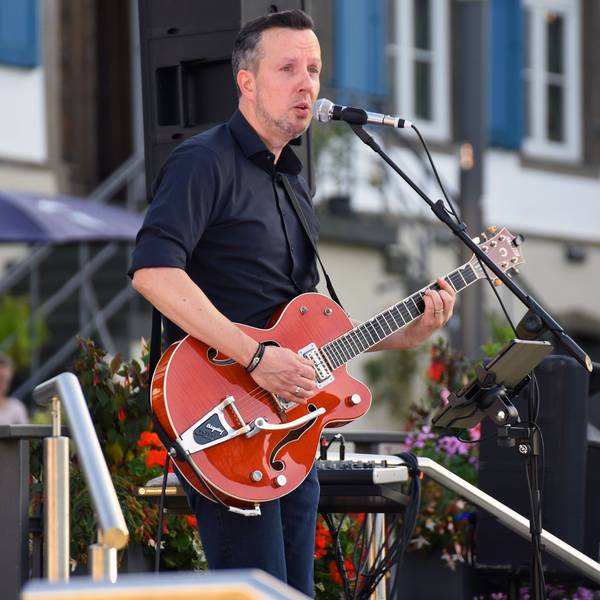 Musiker Daniel Sypien mit einer Gitarre in den Händen bei einem Auftritt.