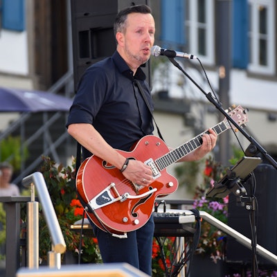 Musiker Daniel Sypien mit einer Gitarre in den Händen bei einem Auftritt.