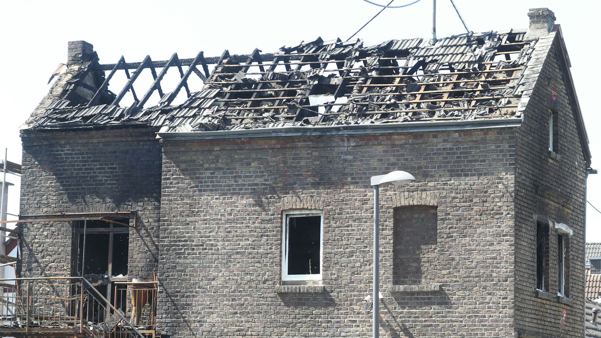Das Backsteinhaus in der Siegstraße in Troisdorf-Bergheim am Sonntag: Der Dachstuhl ist völlig ausgebrannt.