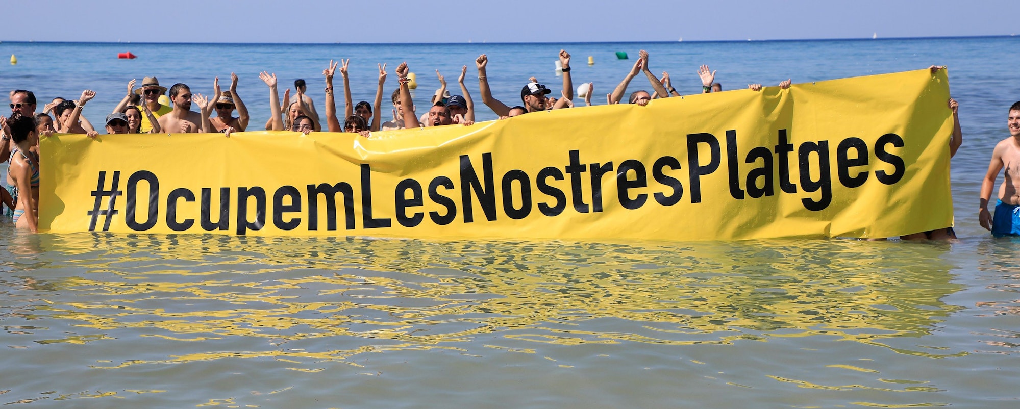 Rund 100 Aktivisten demonstrierten inmitten überraschter Strandurlauber gegen die Auswüchse des Massentourismus.