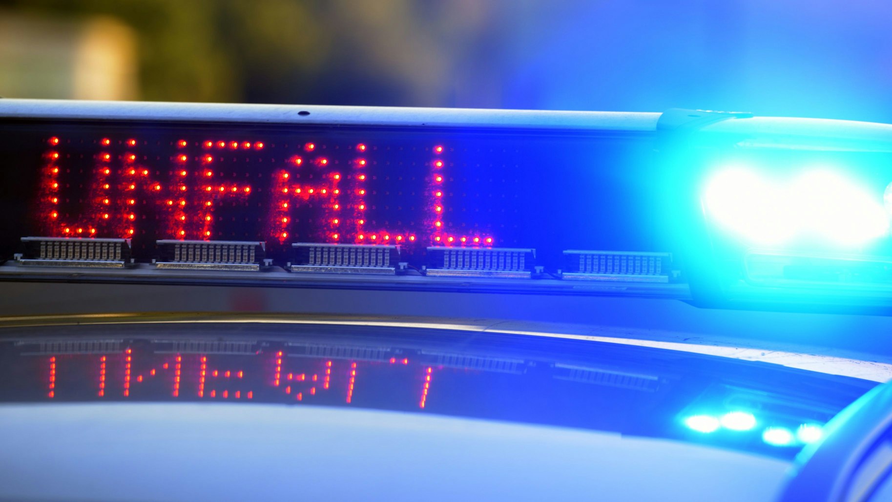 Das Wort Unfall leuchtet auf dem Display eines Polizeiwagens.