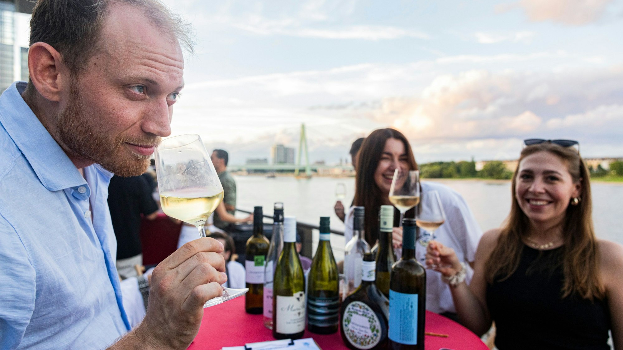 Menschen probieren im Rheinauhafen verschiedene Weinsorten.