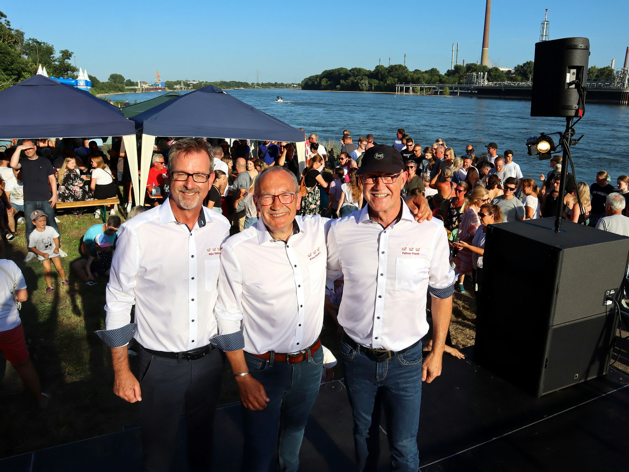 Drei lachende Männer stehen nebeneinander.