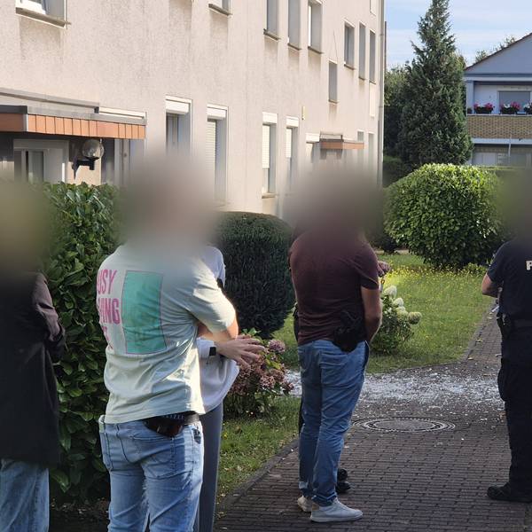 12.08.2024, Nordrhein-Westfalen, Köln: Einsatzkräfte stehen nach einer Explosion an einem Mehrfamilienhaus im Stadtteil Zündorf.