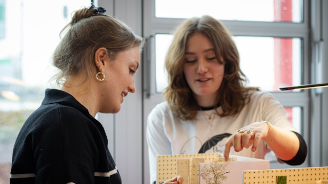 Zwei Studierende erklären ein von ihnen entworfenes Modelle eines flexiblen Büros.