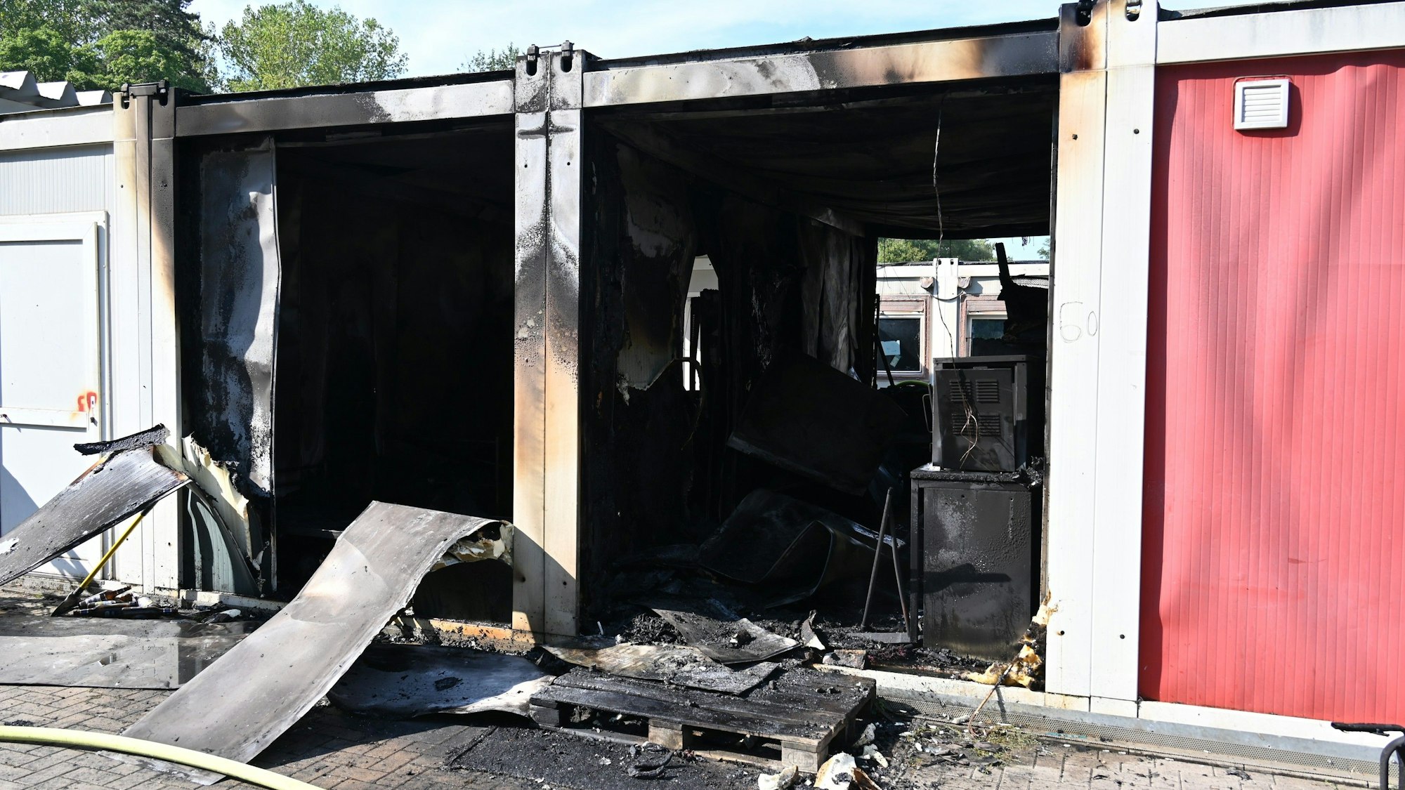 Das Bild zeigt zwei ausgebrannt Wohncontainer der Flüchtlingsunterkunft Mühlenbach in Frechen.