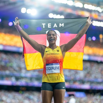 Yemisi Ogunleye hält nach ihrem Gold-Erfolg bei Olympia eine Deutschland-Fahne in die Luft.