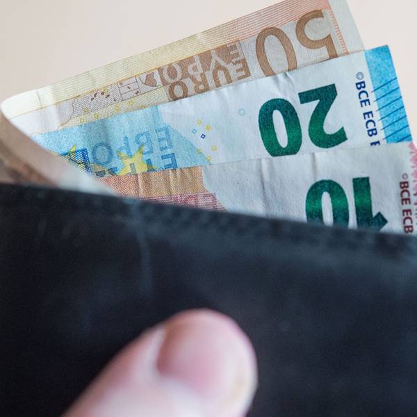 Eine Person hält ein Portemonnaie mit Geld in der Hand. (Symbolbild)