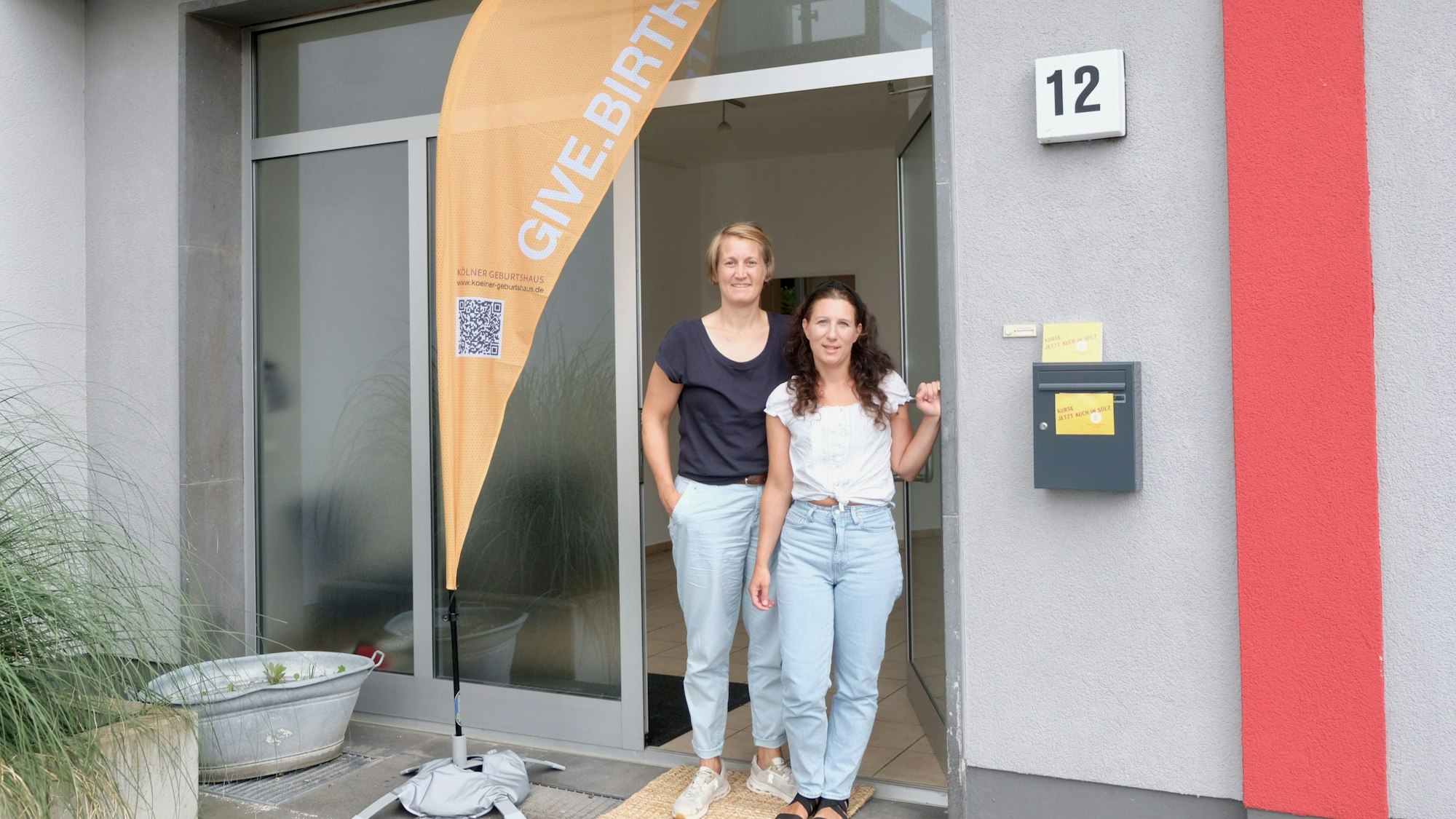Friederike Hoffmann und Rania Dimtsia (v.l.) im Eingang der neuen Hebammenpraxis am Hermeskeiler Platz.
