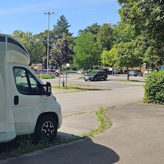 Ein Wohnmobil steht auf einem Parkplatz in Kaster.