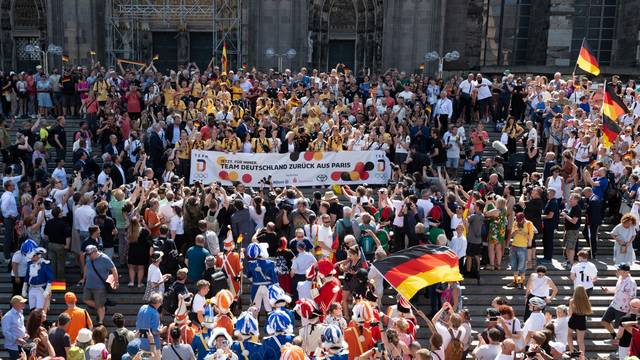 Die deutschen Athleten werden nach ihrer Ankunft am Hauptbahnhof Köln am Tag ihrer Abreise nach Abschluss der Olympischen Spiele vor dem Kölner Dom in Empfang genommen.