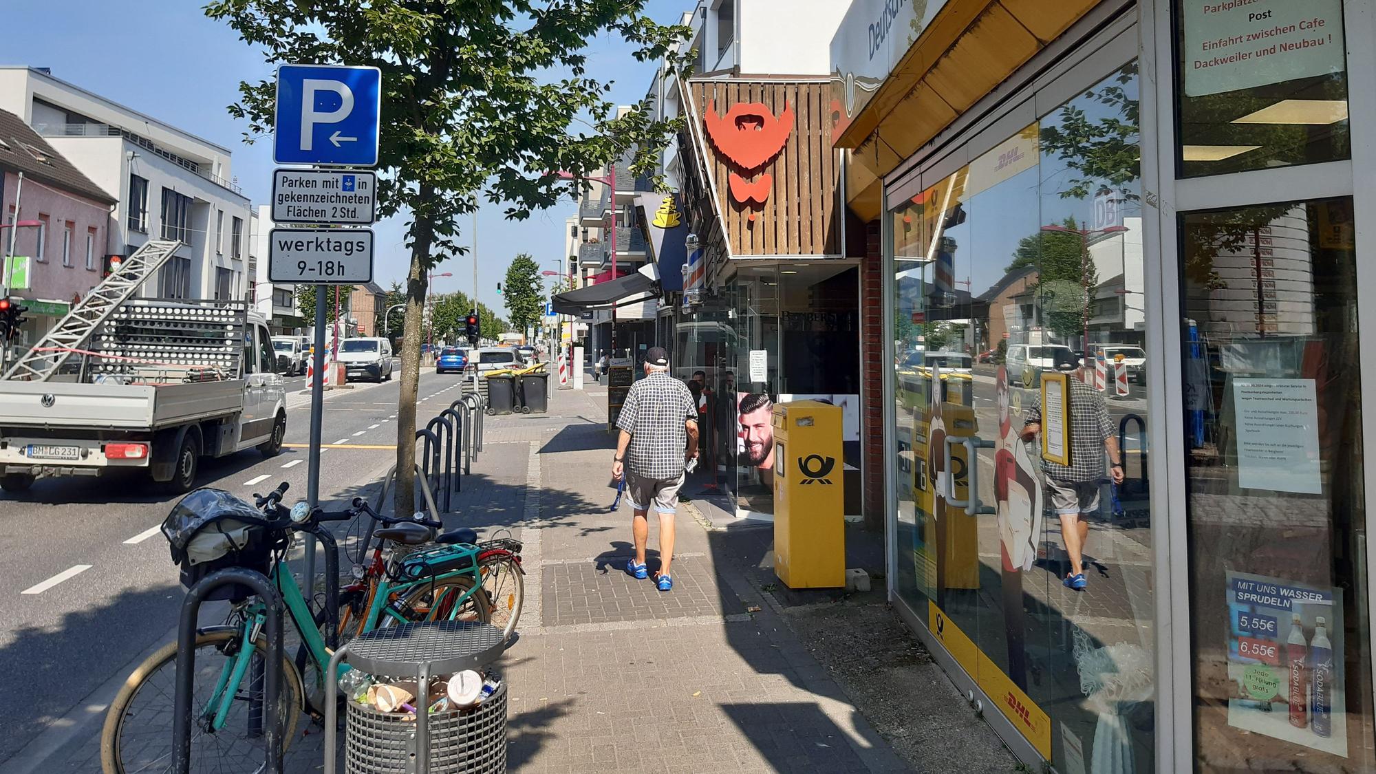 Auf dem Bild ist die Kerpener Straße rund um das Café Dackweiler zu sehen, ein älterer Herr flaniert über den Bürgersteig.