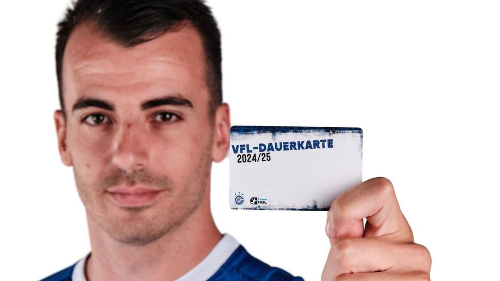 VfL-Spieler Milos Vujovic hält eine Dauerkarte des VfL Gummersbach in die Höhe.
