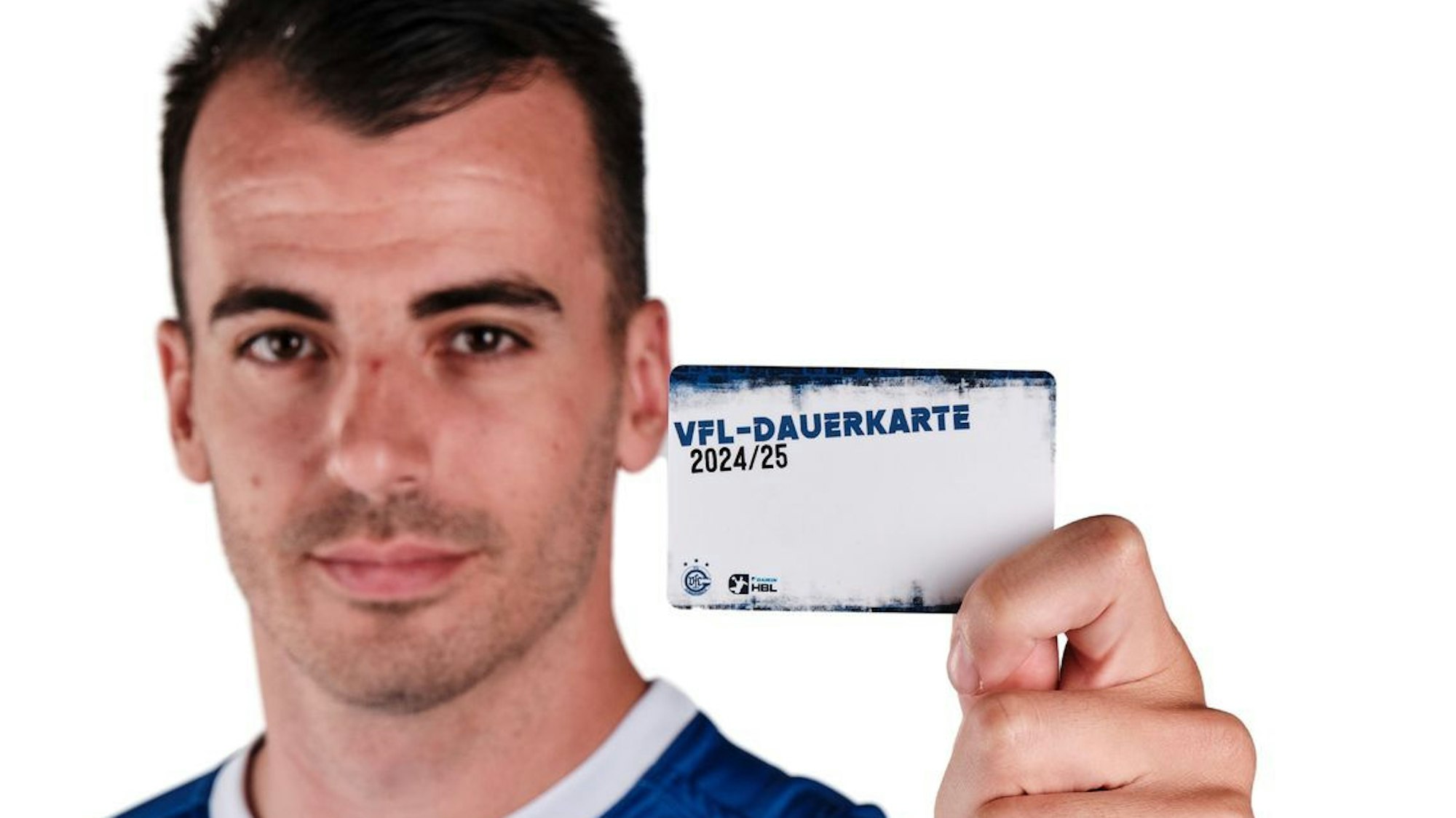 VfL-Spieler Milos Vujovic hält eine Dauerkarte des VfL Gummersbach in die Höhe.