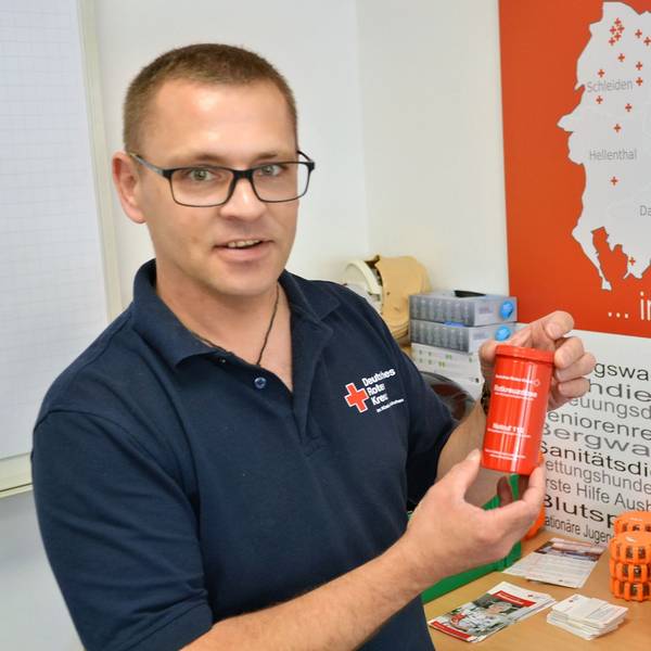 Sascha Kray hält einer der „Rotkreuzdosen“ in der Hand.
