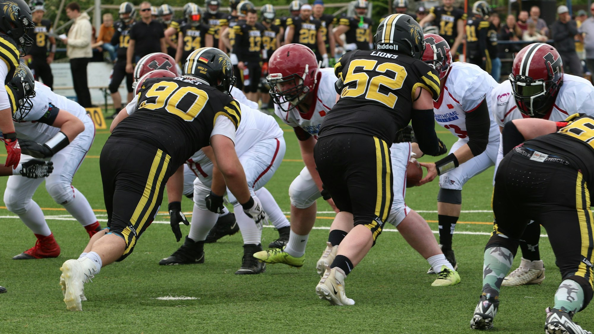 Zwei Football-Mannschaften laufen aufeinander zu.