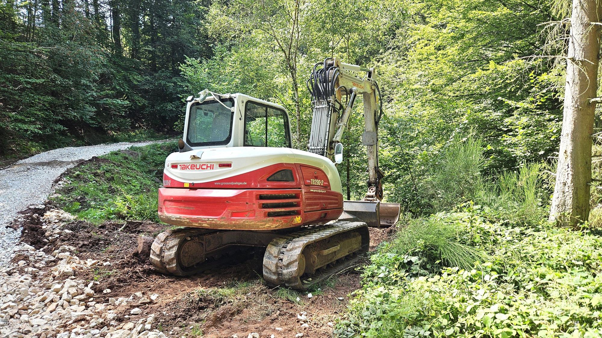 Ein Bagger arbeitet im Wald.