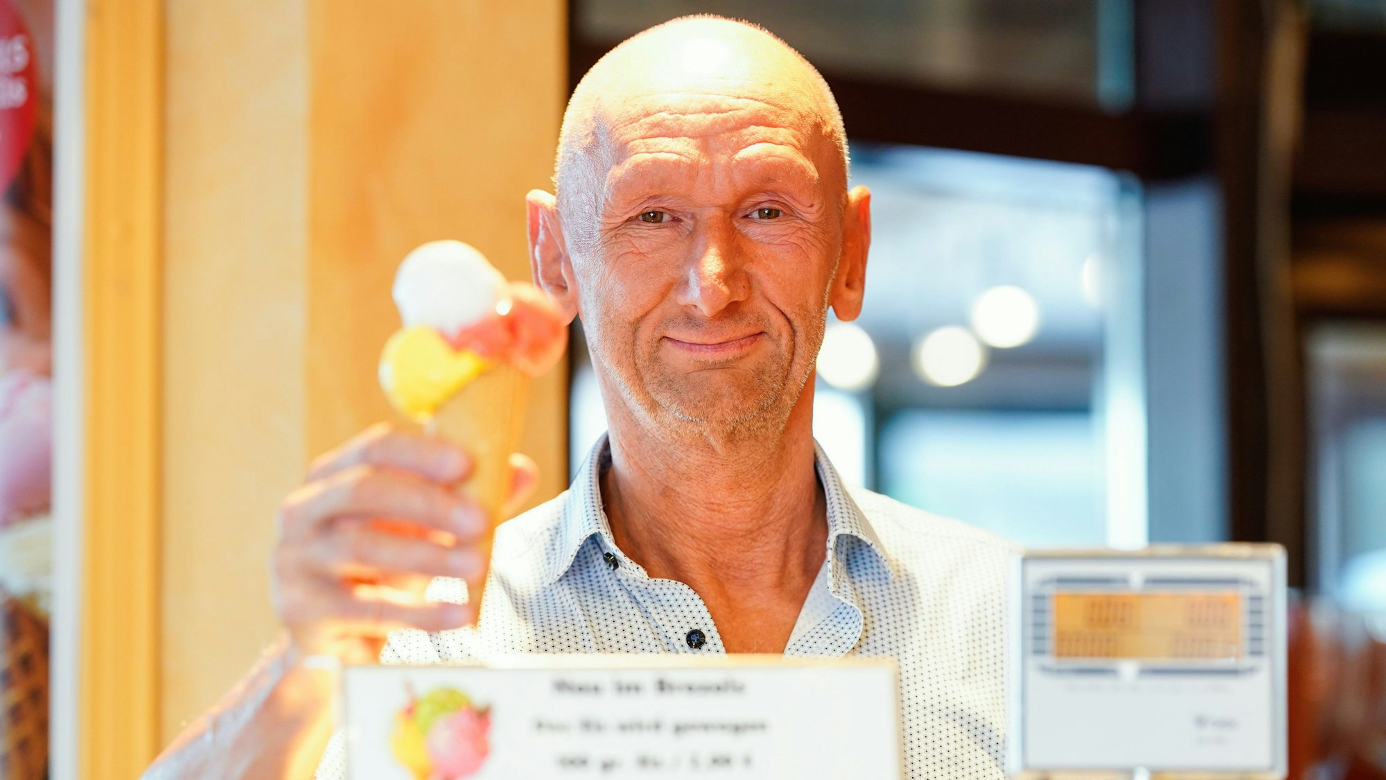 Baden-Württemberg, Gaggenau: Betreiber Michael Böhmer stellt im Café ·Brezels· ein Eis in einer Waffel auf die Waage.