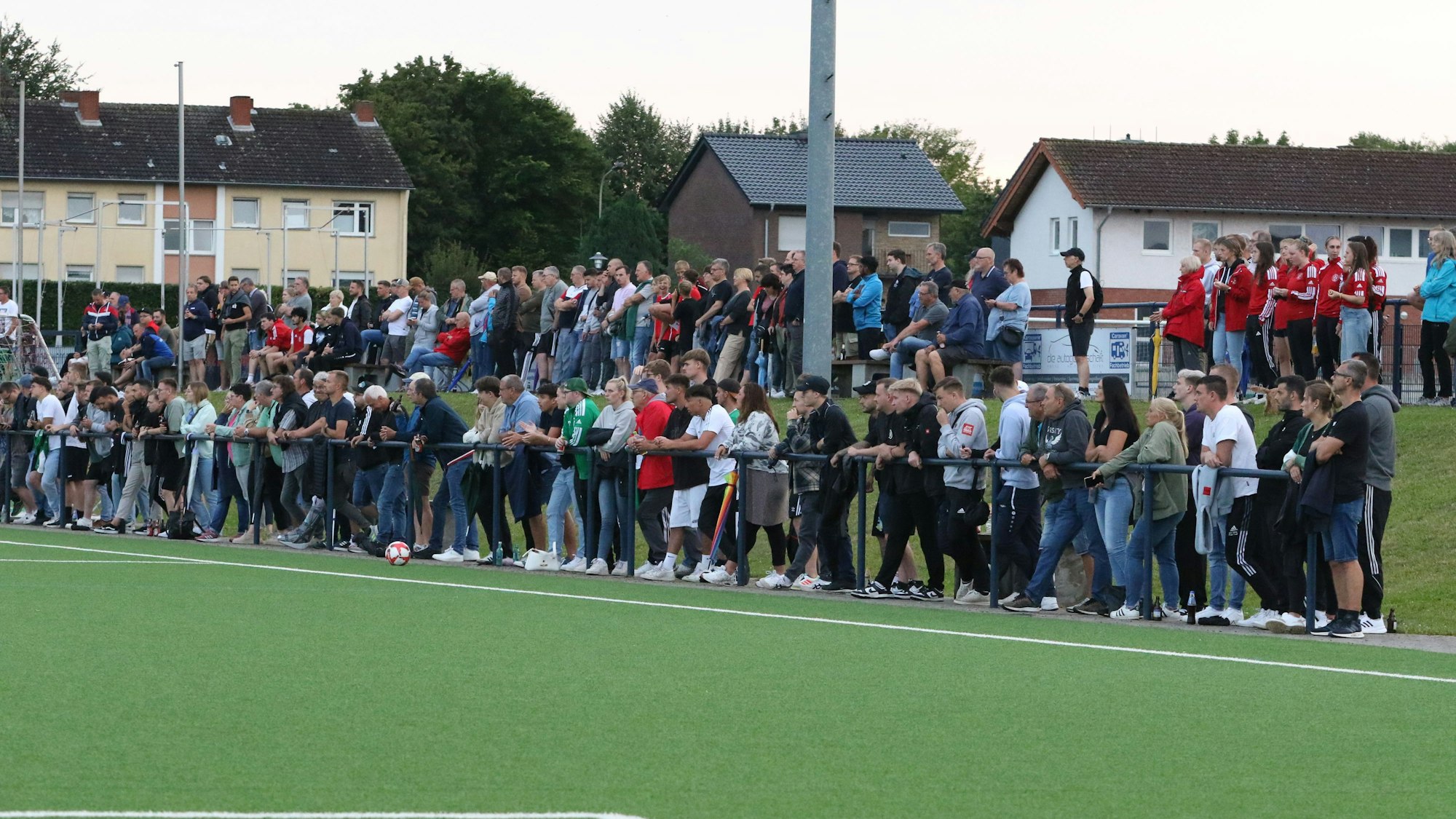 Am Spielfeldrand stehen Hunderte Zuschauer, die das Spiel verfolgen.