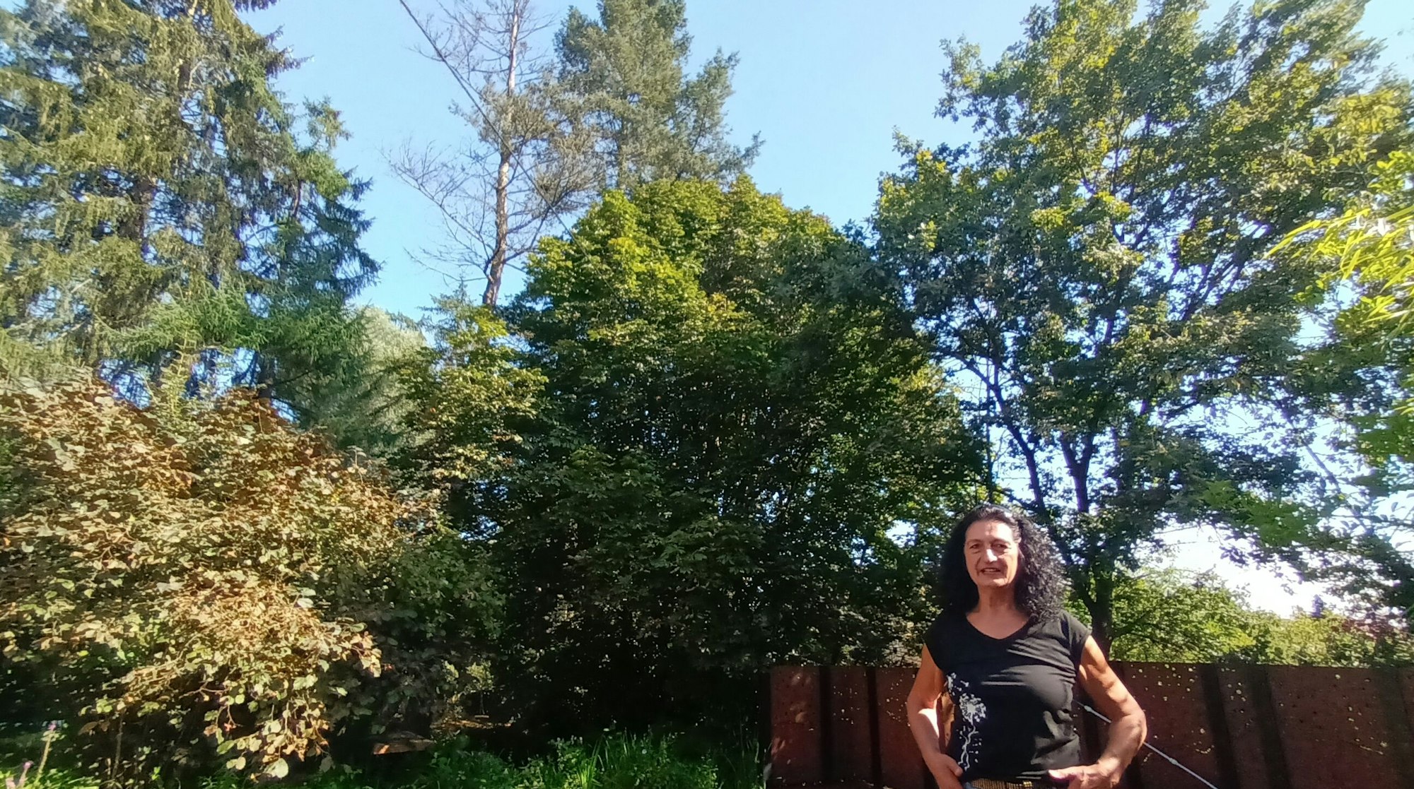 Eine Frau steht vor Bäumen