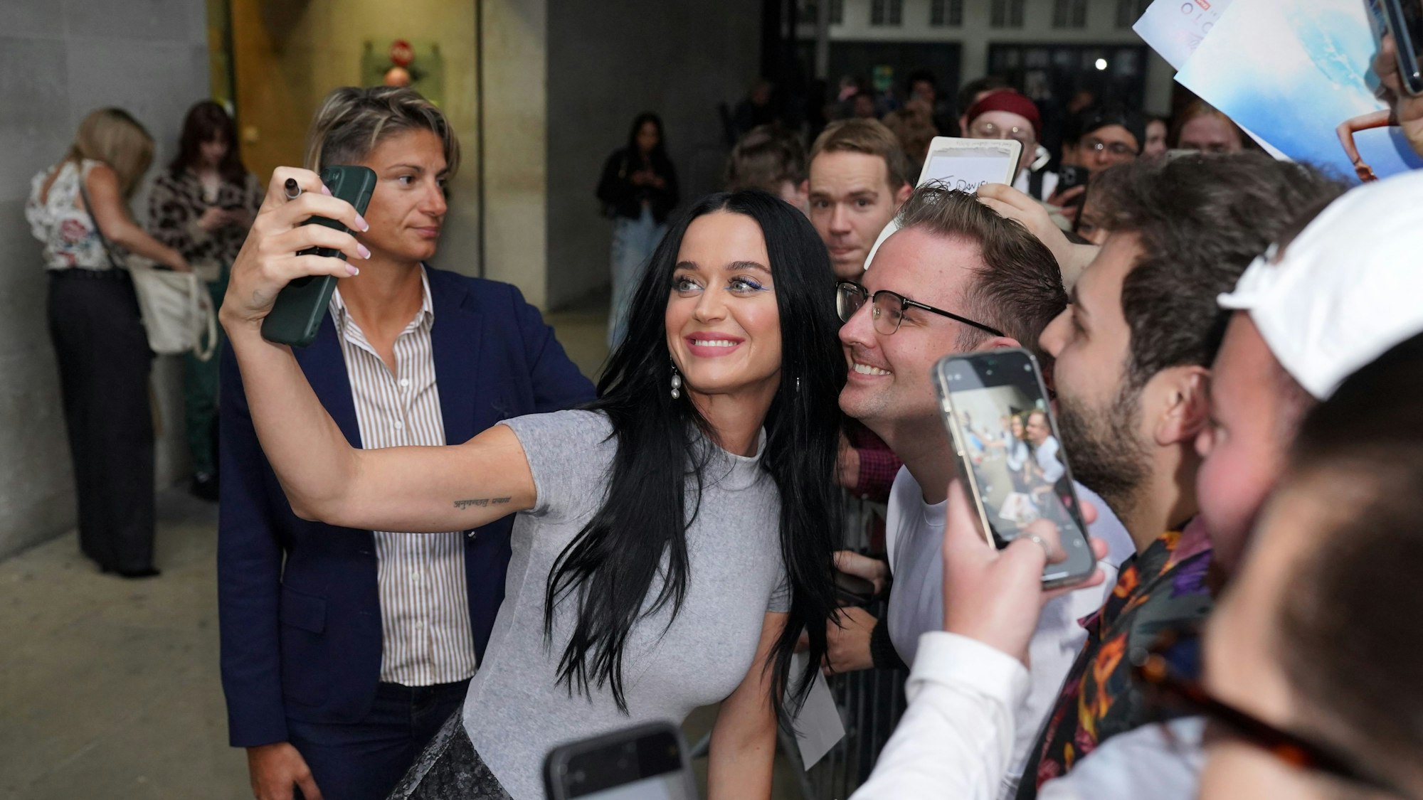25.07.2024, Großbritannien, London: US-Sängerin Katy Perry macht ein Selfie mit einem Fan, während sie das Studio der One Show im BBC Broadcasting House in London nach ihrem Auftritt in der The One Show verlässt. Foto: Jonathan Brady/PA Wire/dpa +++ dpa-Bildfunk +++