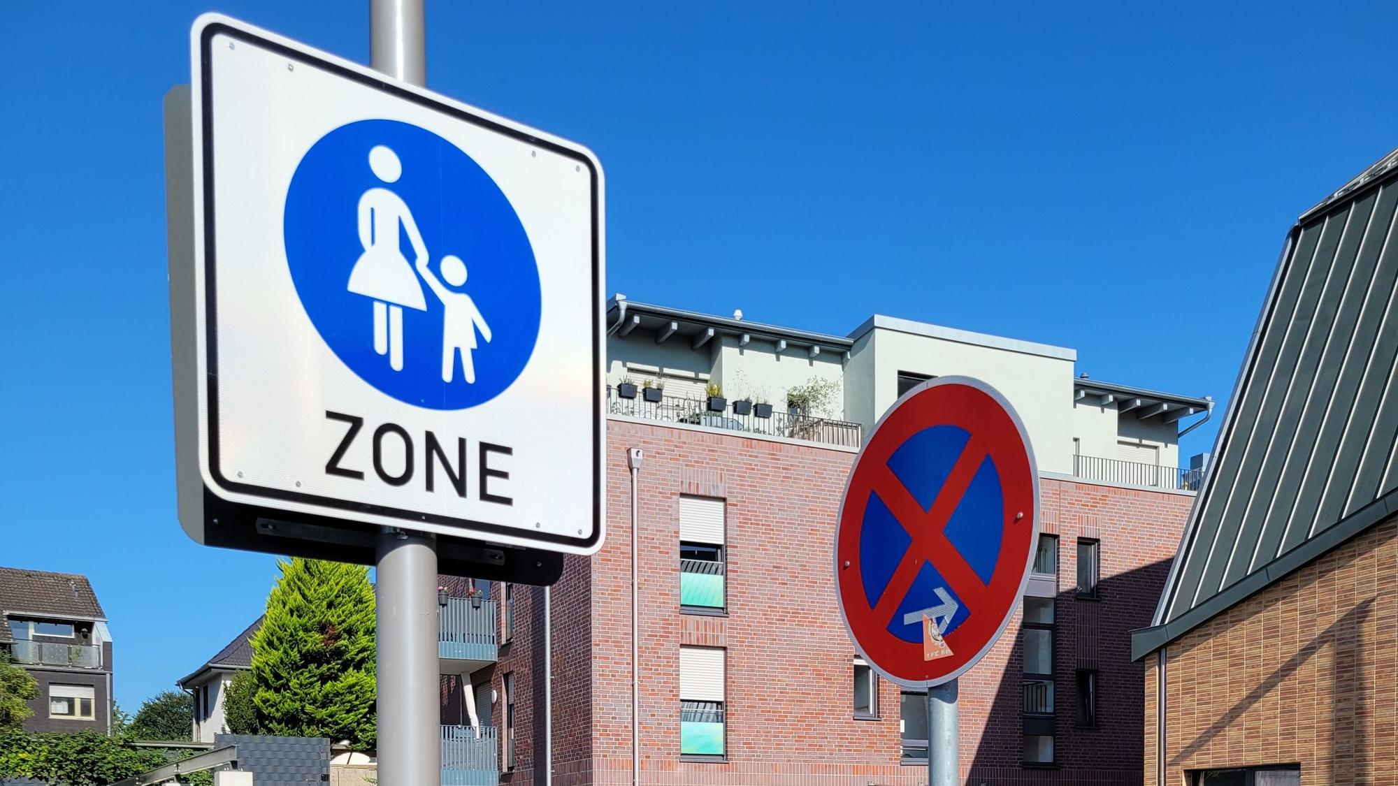 Im Bild zwei Verkehrsschilder, eines weist auf ein absolutes Halteverbot hin, das andere auf eine Fußgängerzone.