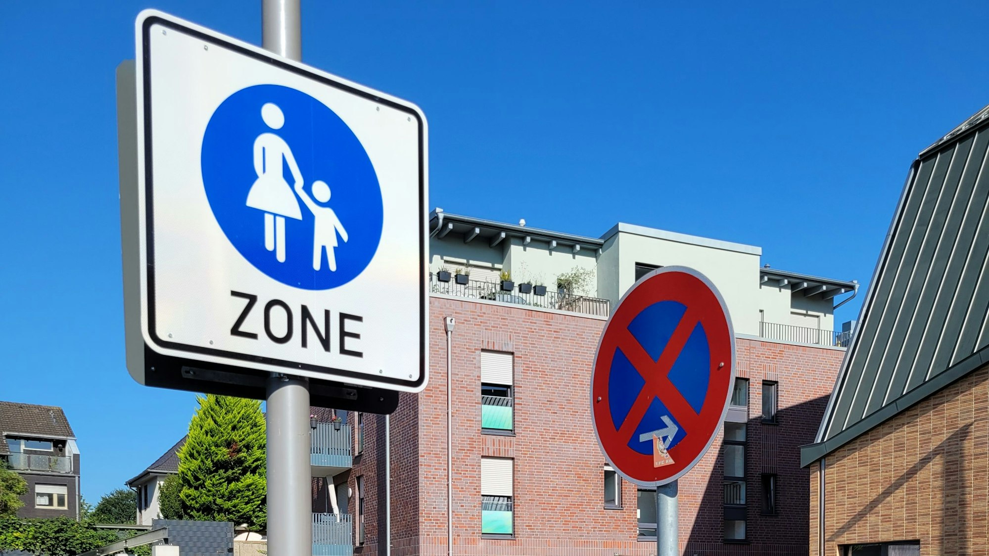 Im Bild zwei Verkehrsschilder, eines weist auf ein absolutes Halteverbot hin, das andere auf eine Fußgängerzone.