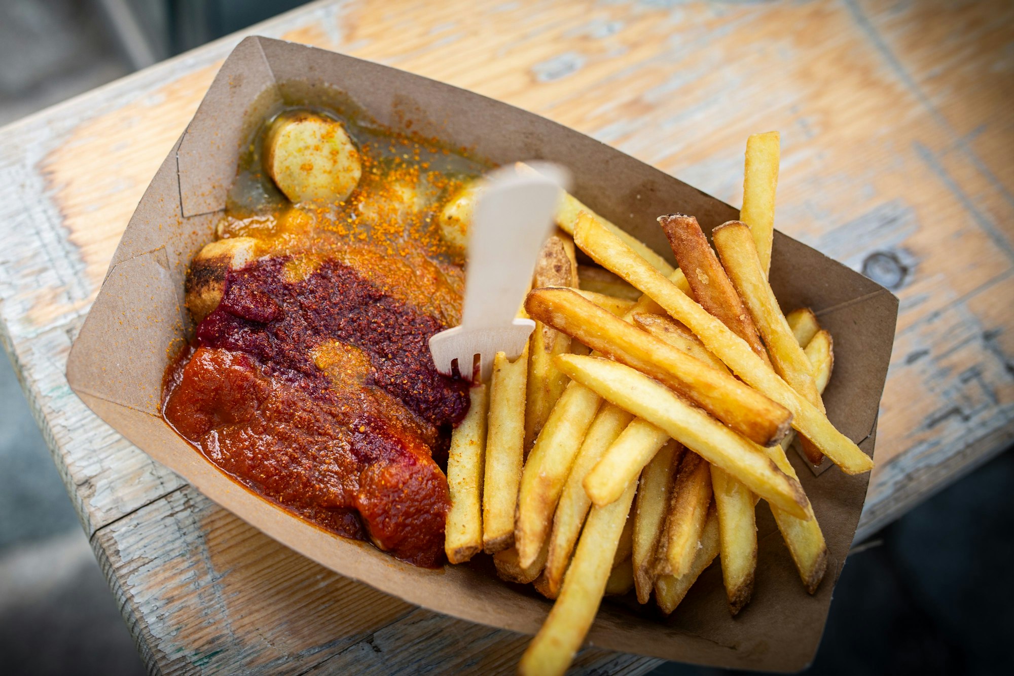 Die „Curry Vurst“ wird mit Pommes und vier verschiedenen Soßen serviert.