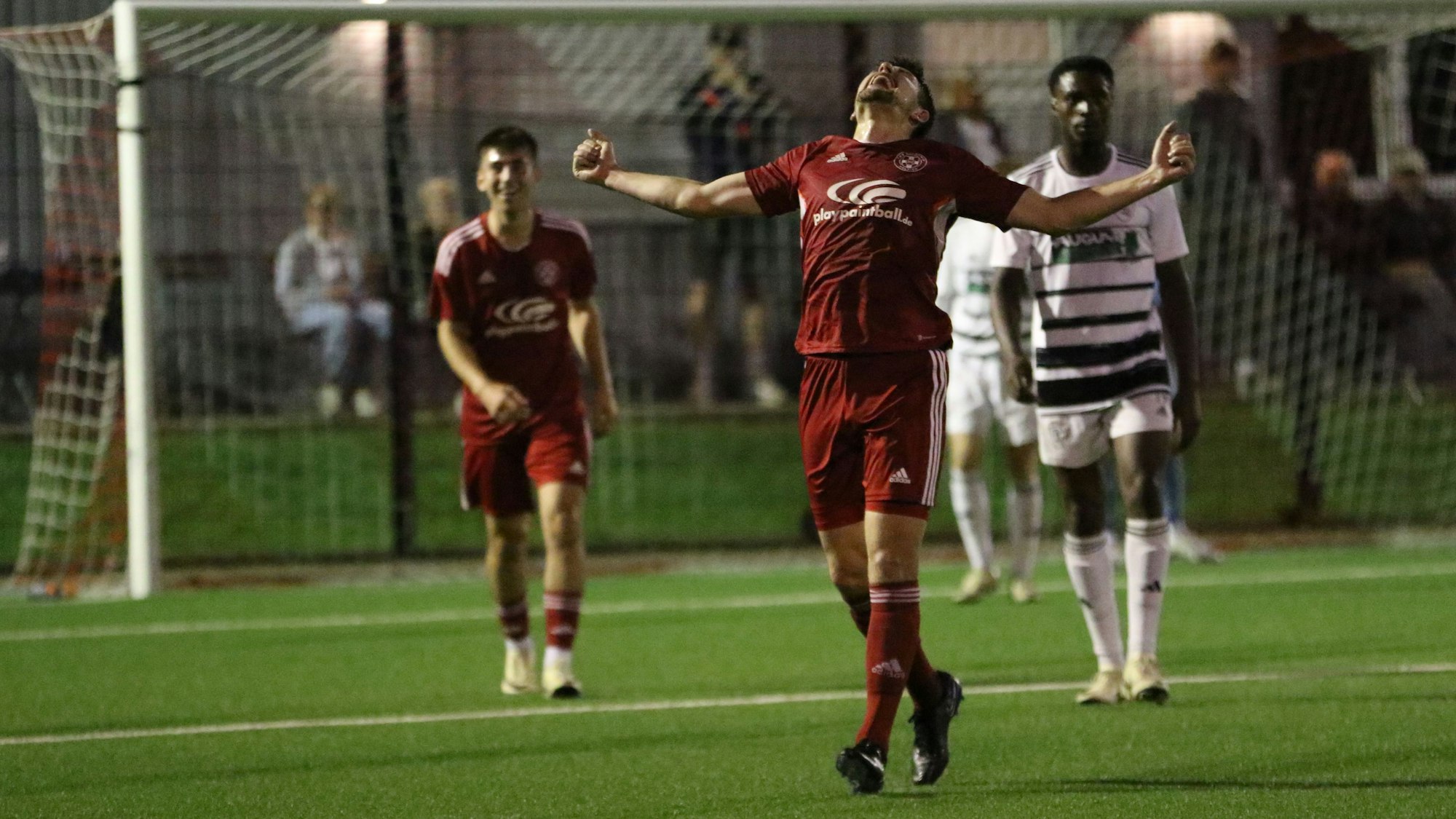 Zülpichs Torschütze breitet die Arme aus und blickt in den Himmel. Ein Mitspieler im Hintergrund freut sich, ein Gegenspieler weniger.