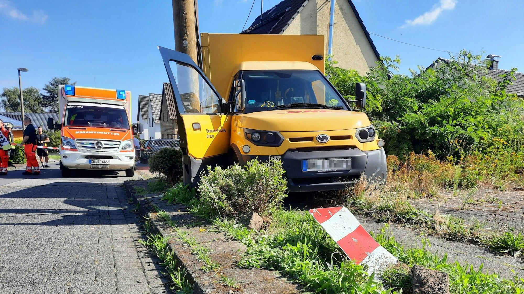 Ein Postauto steht in der Straße Herzeleid in Königswinter-Thomasberg eingeklemmt an einem Strommast.